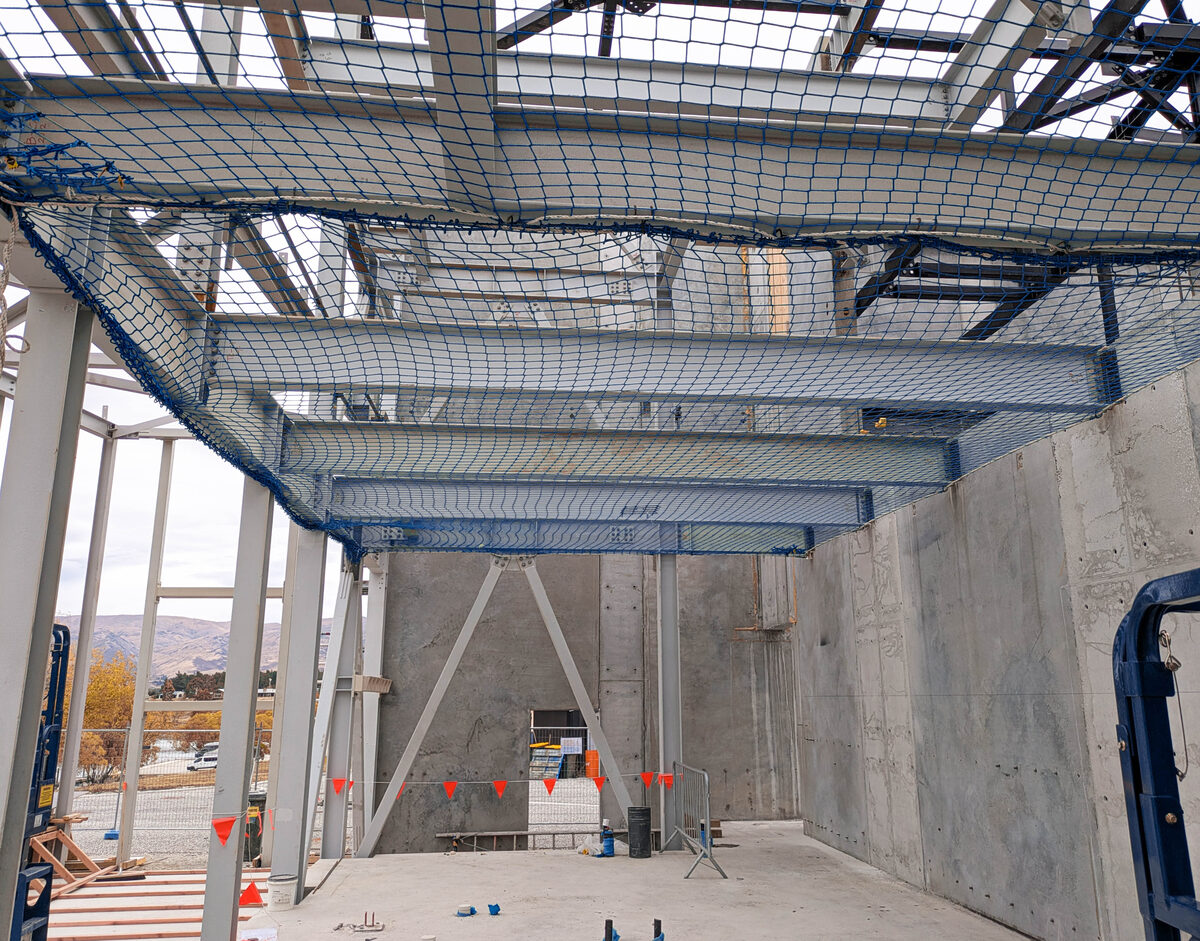 Safety nets installed beneath steel framing inside a commercial building